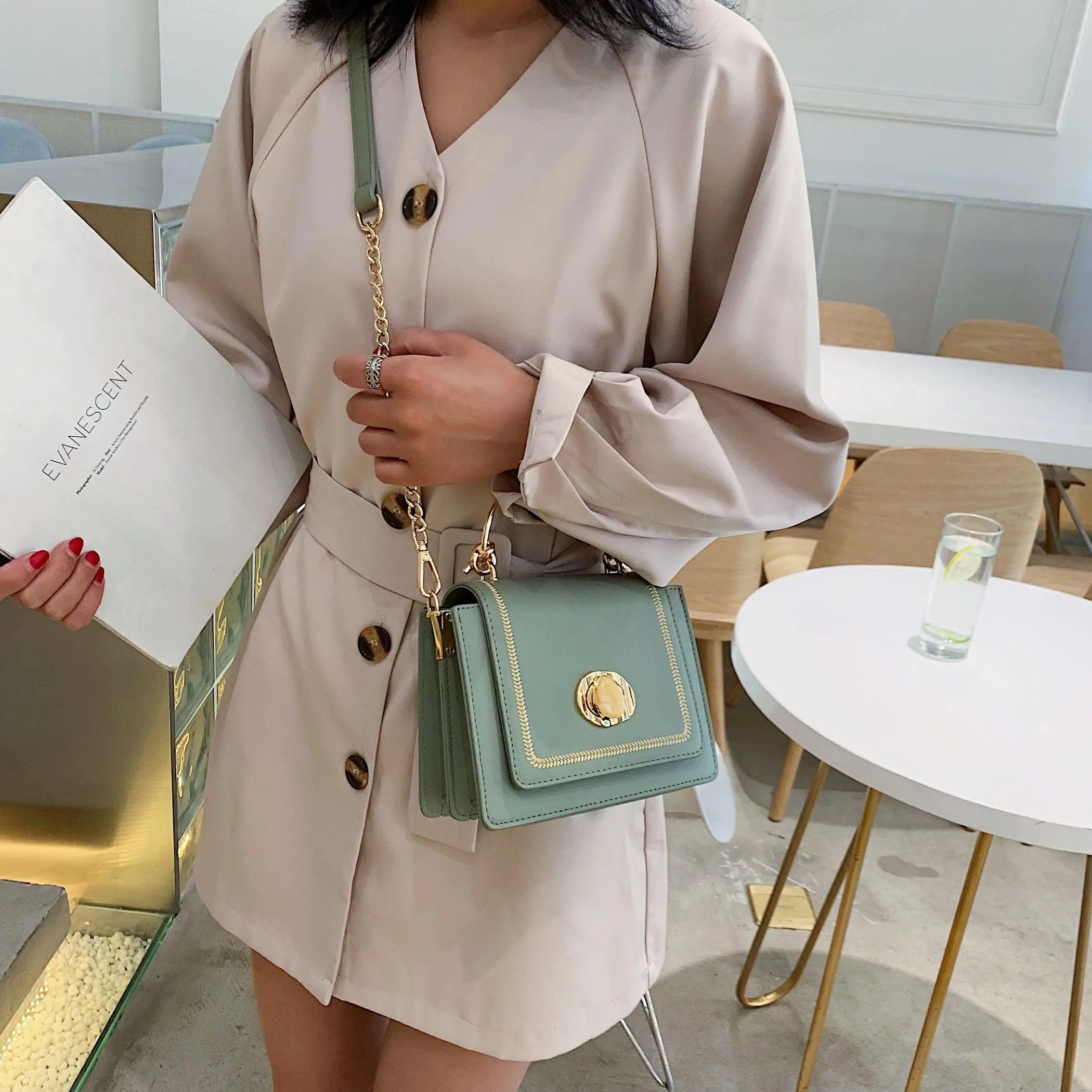 Fashionista Crossbody Bag in green with chic design and gold accents, worn by model in neutral outfit.