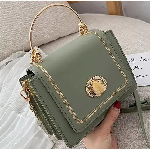 Fashionista Crossbody Bag in green with gold accents, featuring a sleek design and adjustable strap.