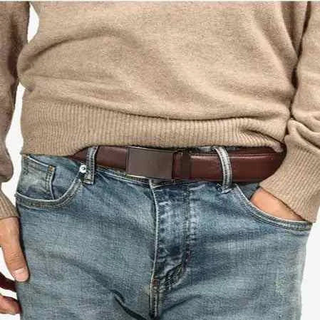 Men's brown leather belt with a metal buckle, worn with jeans and a beige sweater.